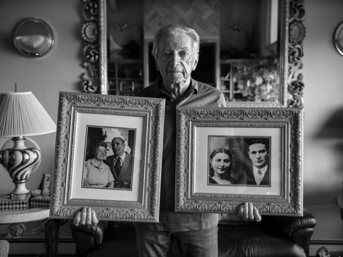 Leon and his family were living in the town of Compiègne, occupied France, when the French police came for his parents. Leon was four and his older sister Rachel was ten. The downstairs neighbors told Leon's parents and the police that they would look after the children until the parents were released. They never returned. Leon's mother, Chana, died either on the way to Auschwitz or immediately upon arrival, as she was never tattooed. She was 31. His father Srul died in 1944 at age 38, a few months before the camp was liberated. The downstairs neighbors, Henri and Suzanne Ribouleau, became the childrens’ second parents. Leon is holding portraits of the four people he considers his parents. In his left hand a portrait of his parents, last seen being taken away by the French police in 1942, and in his right, his second parents, who took in Leon and his sister on that day, instead of letting the police take them away as well.